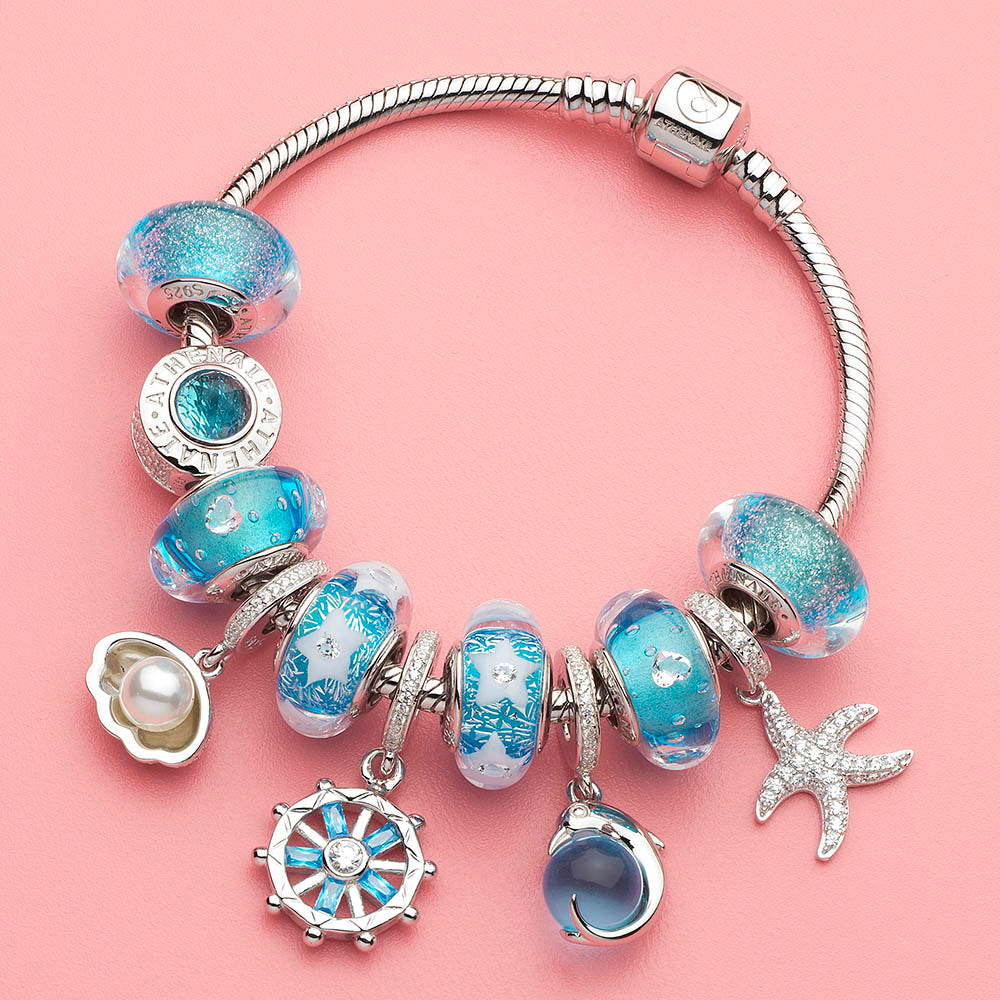 Sparkling dolphin charm paired with ocean-inspired charm bracelet