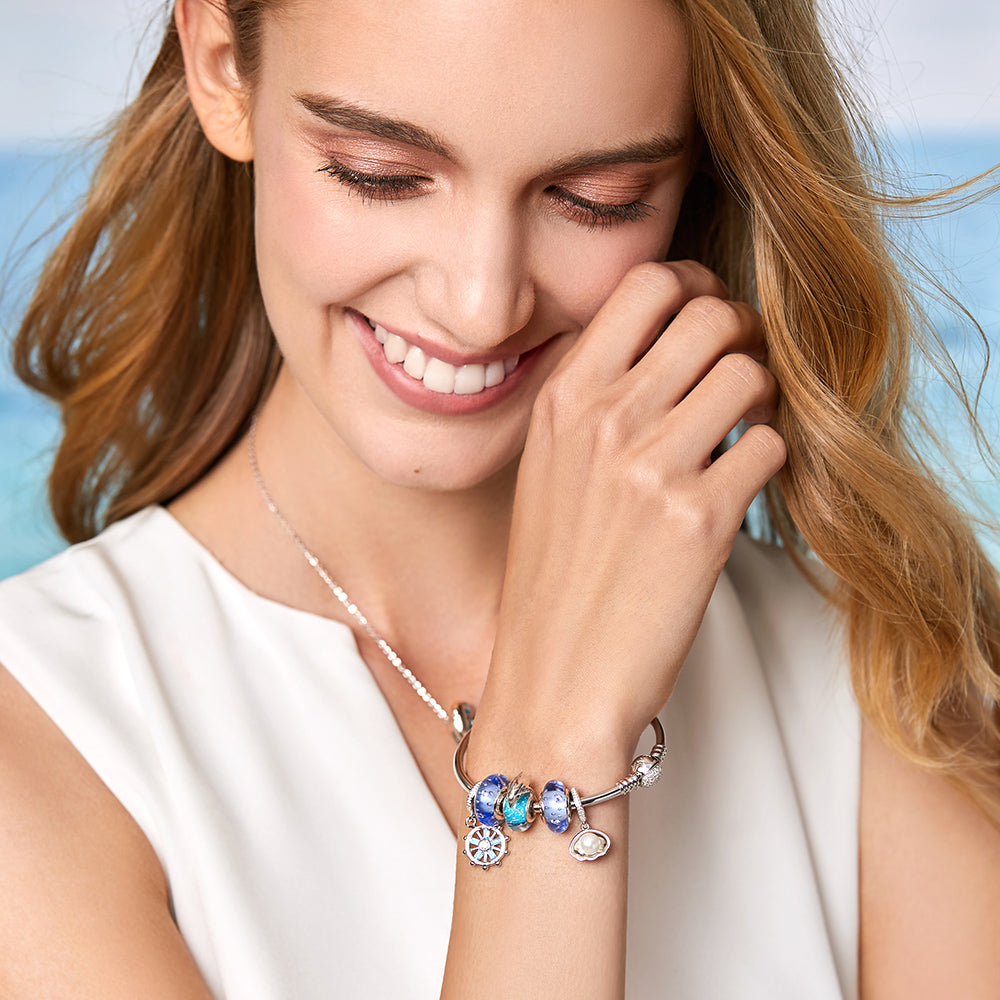Model wrist featuring dolphin charm bead on silver bracelet – ocean style jewelry