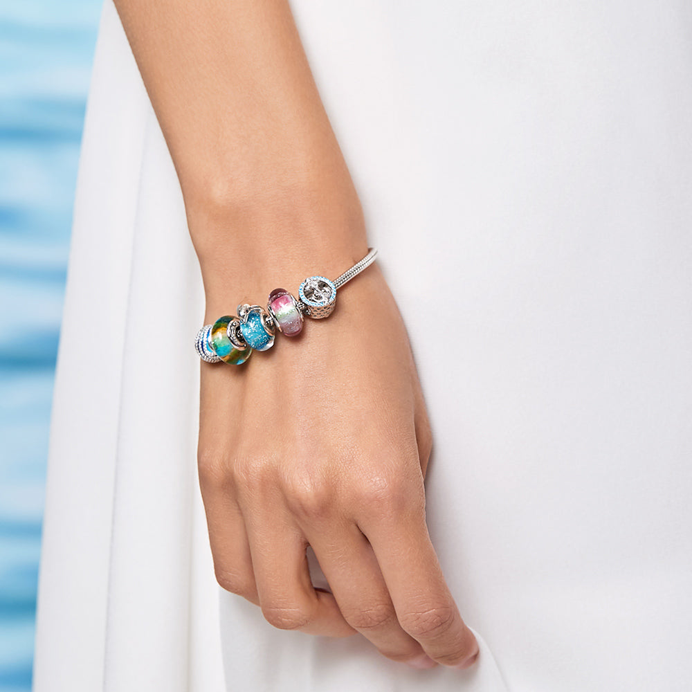Close-up of dolphin Murano charm on bracelet worn by model – handcrafted glass detail