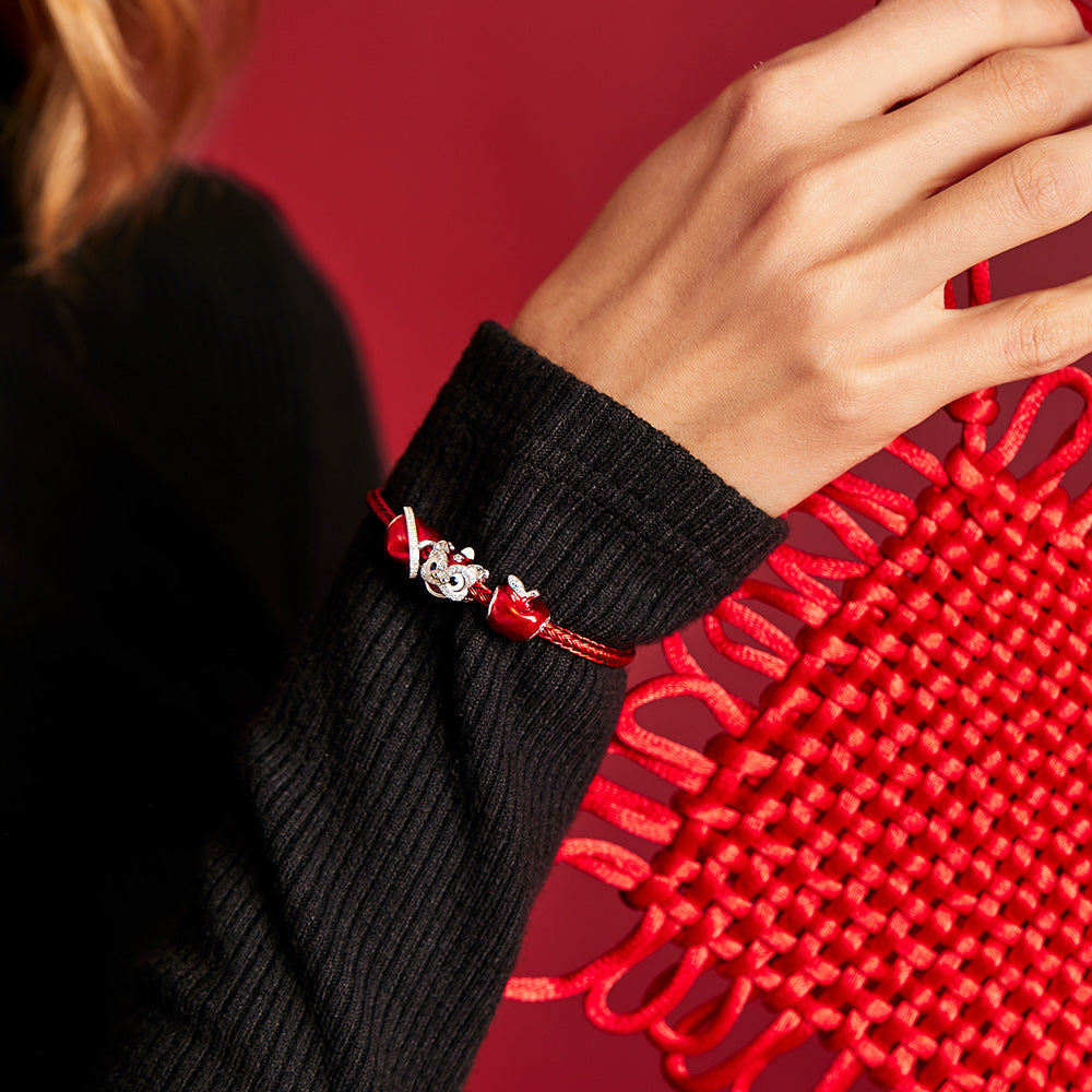 Woman wearing red lion dance charm on silver bracelet – close-up view