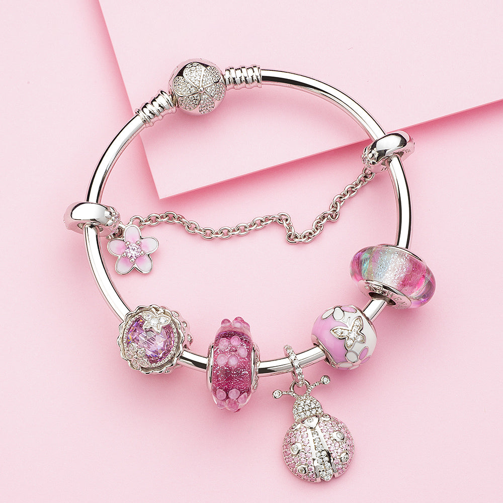 Rainbow charm bead styled on silver bracelet with multiple beads in lifestyle scene