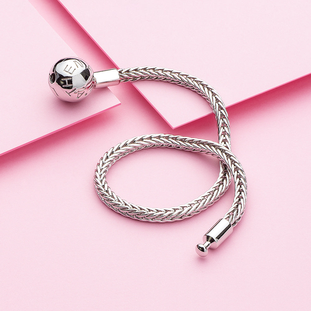 Elegant silver wheat charm bracelet styled with jewelry props