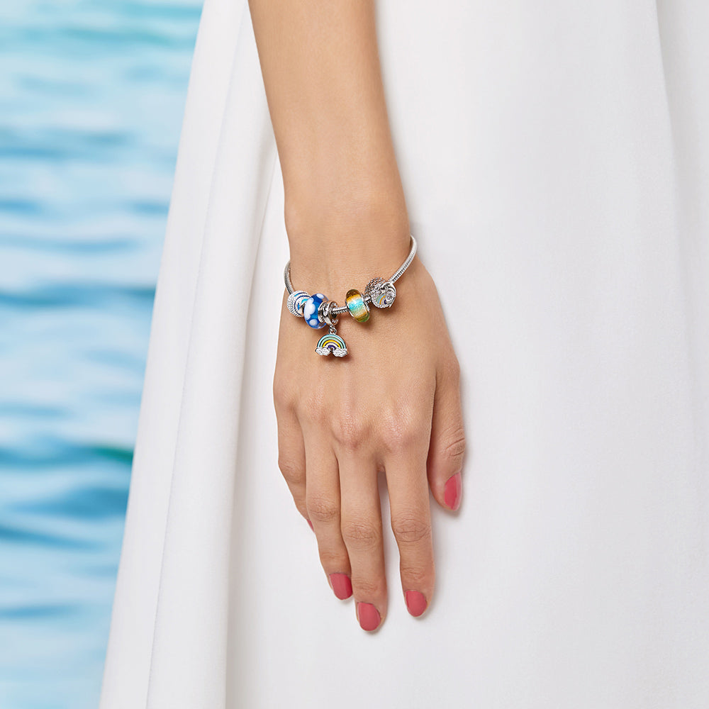 Elegant model wearing Rainbow Dreams 925 sterling silver rainbow charm bracelet