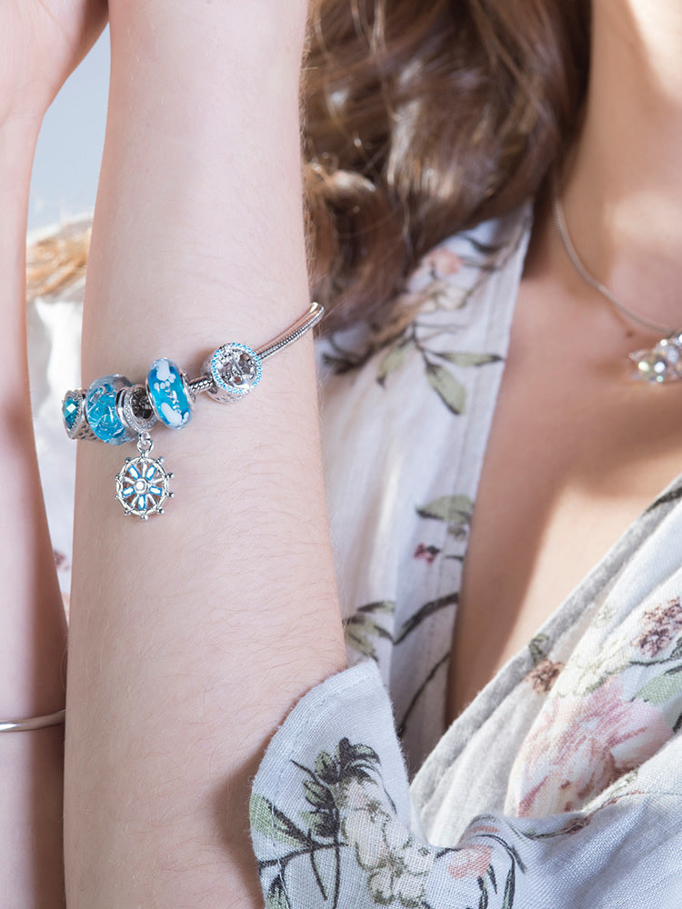 Baby footprint Murano glass bead styled on charm bracelet worn by model by ATHENAIE