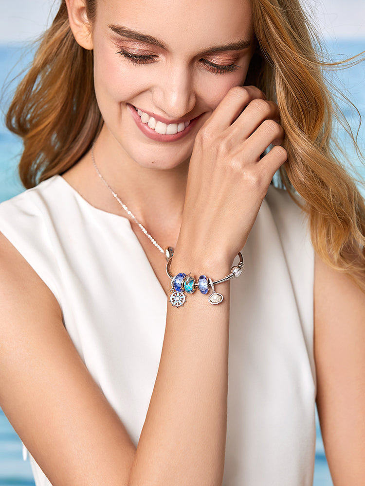 Blue dolphin Murano charm ocean inspired jewelry gift styled on feminine silver bracelet