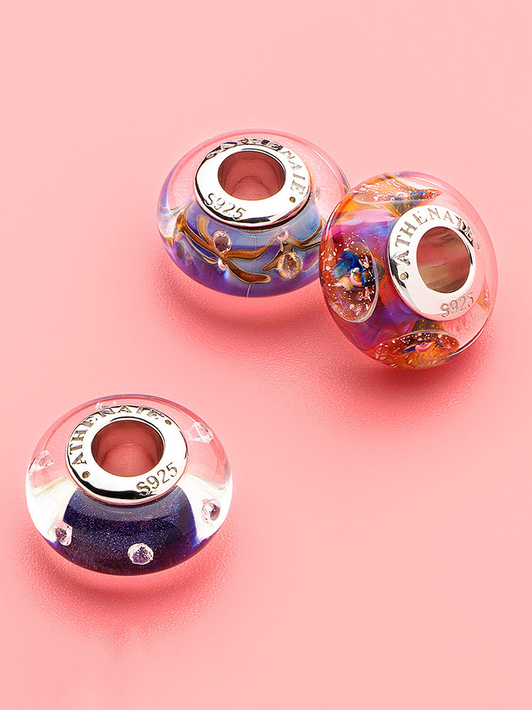 Close view of cosmic bloom murano glass charm on European charm bracelet