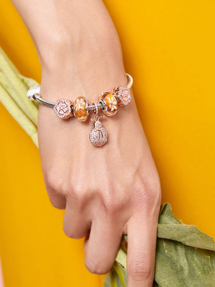 Rose gold flower charm bead worn on sterling silver bracelet