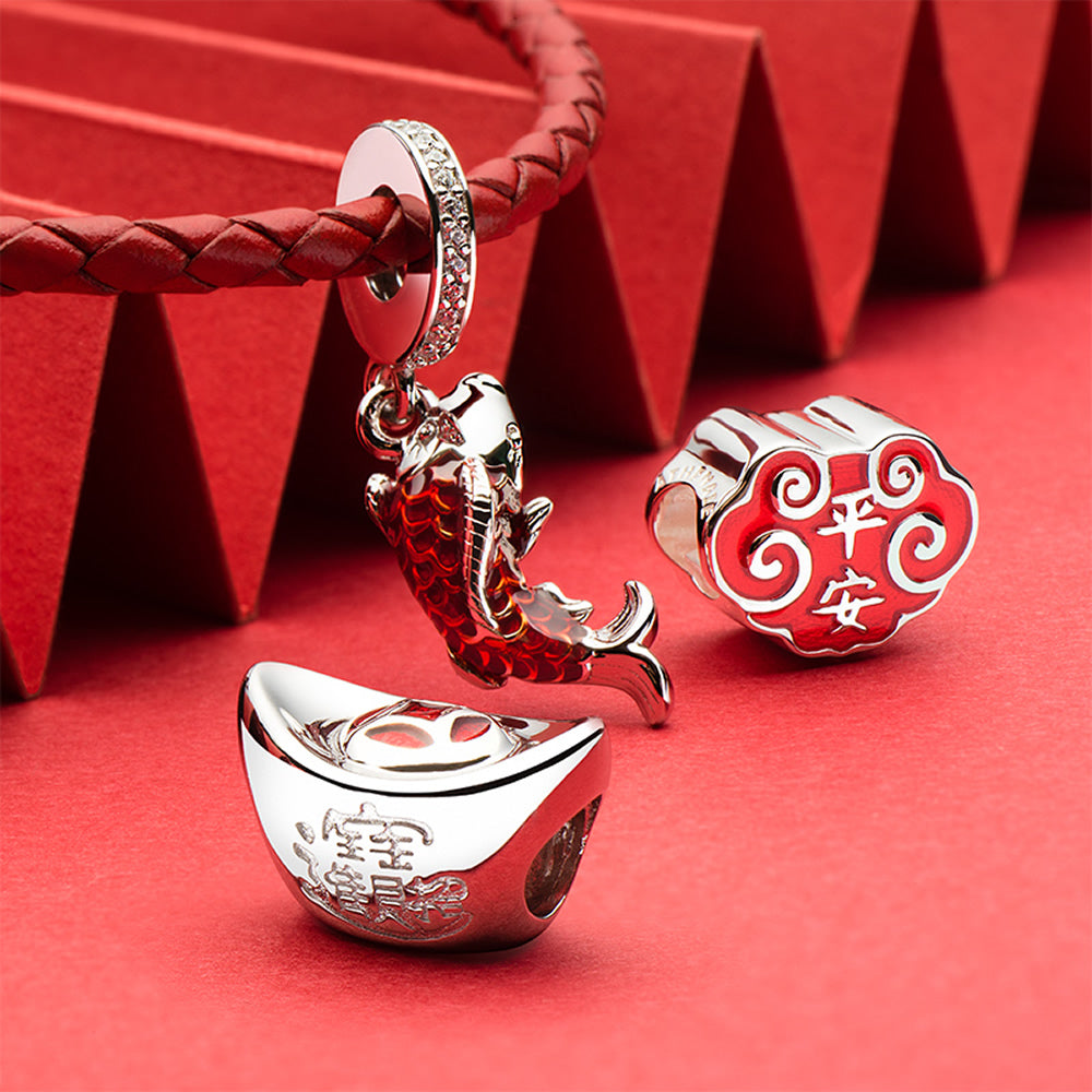 Fortune Ingot charm bead with enamel and silver displayed in a Chinese New Year themed jewelry scene