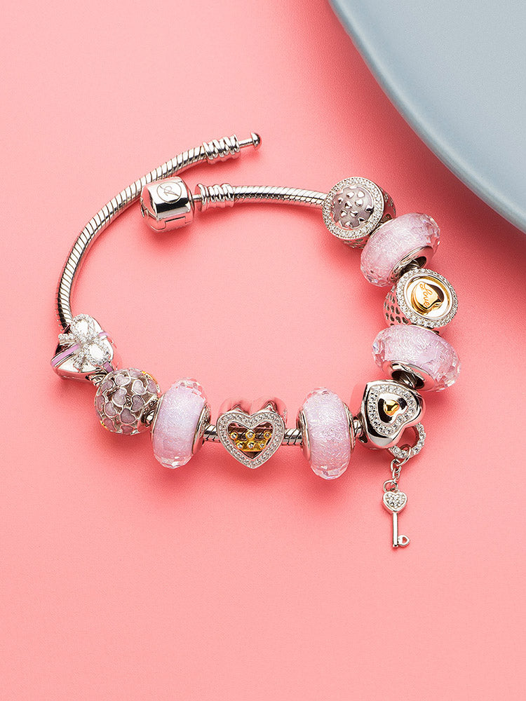 Gold-tone crown charm on a silver charm bracelet