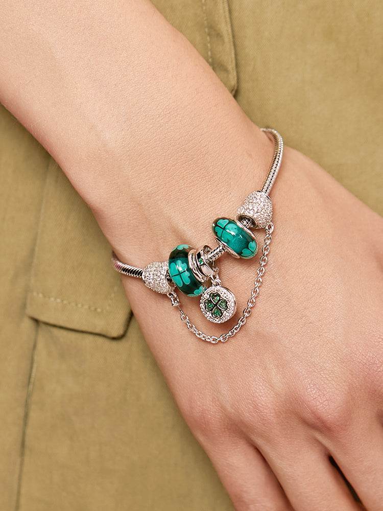 Charm bracelet with the green four-leaf clover Murano glass bead, worn on the wrist