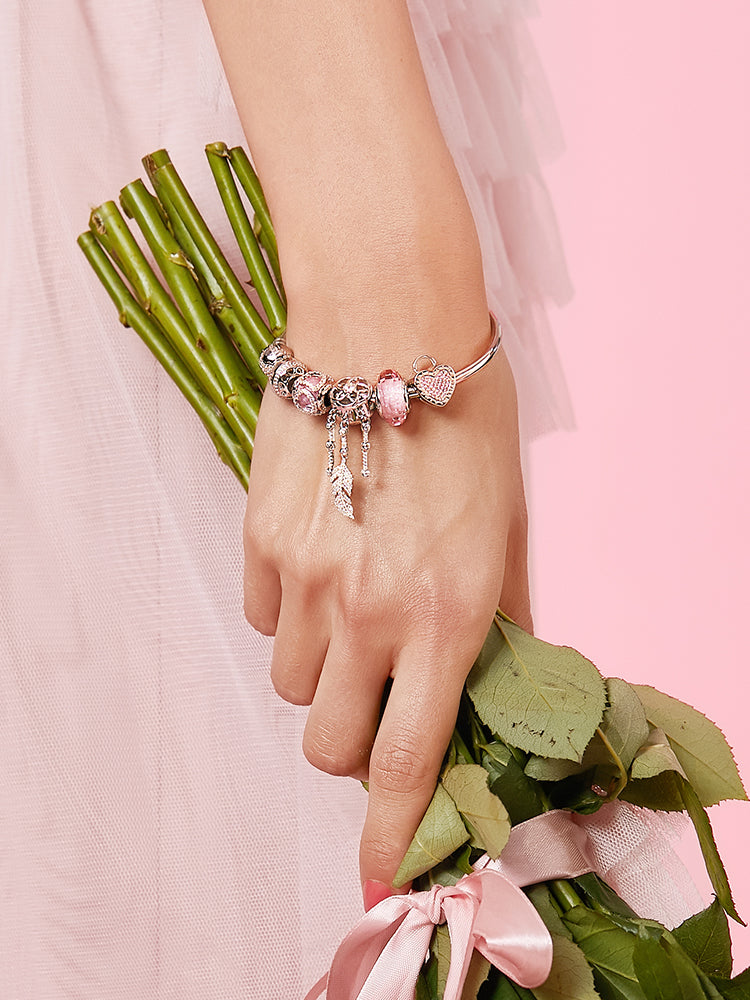 Model wearing charm bracelet with Blush Heart Lock clip charm stopper