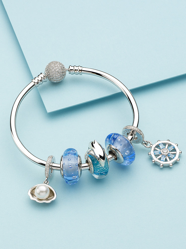 Ocean blue dolphin Murano charm styled on silver bracelet – marine jewelry styling inspiration