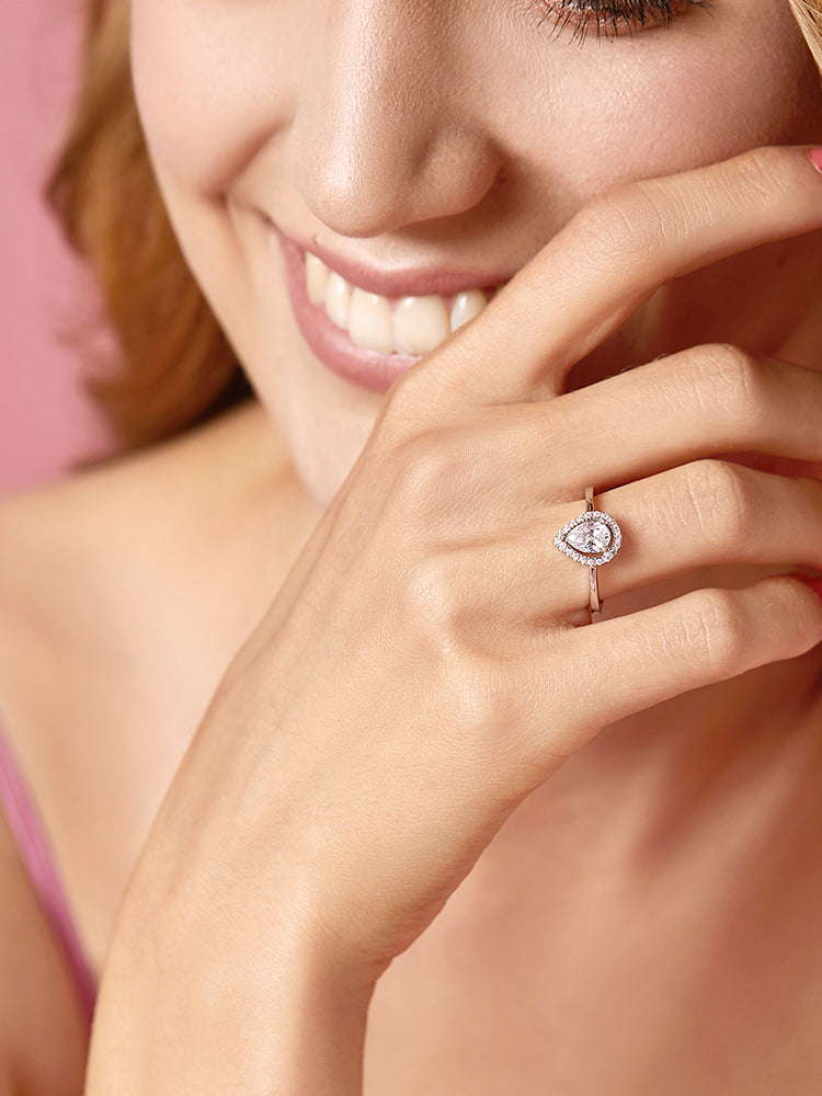 Sterling silver pear halo engagement ring worn on hand