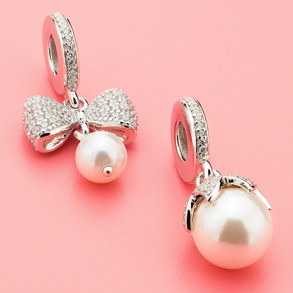 Close-up of Petal Pearl charm pendant styled on bracelet, showcasing soft pearl glow and floral micro-pavé setting