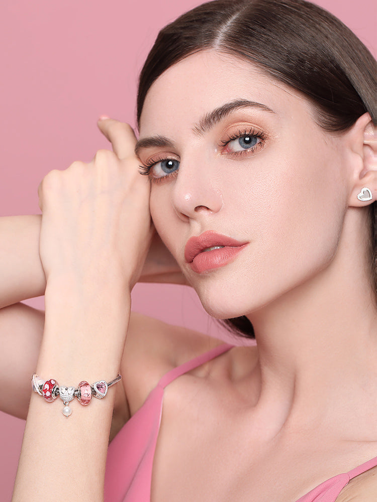 Pink heart charm bracelet worn on model wrist