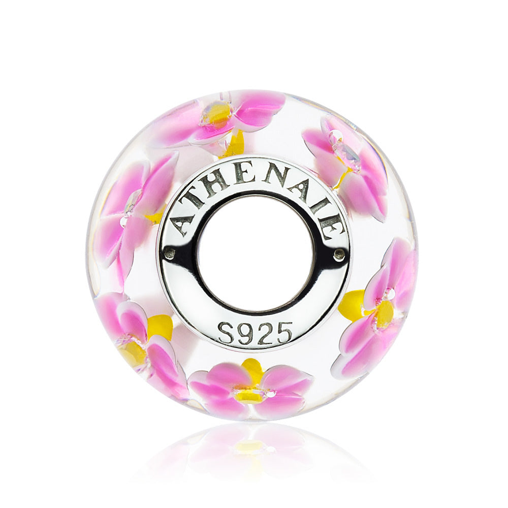 Side view of Primrose Garden charm bead showcasing layered Murano glass and silver core, floral swirl detail with lampwork finish