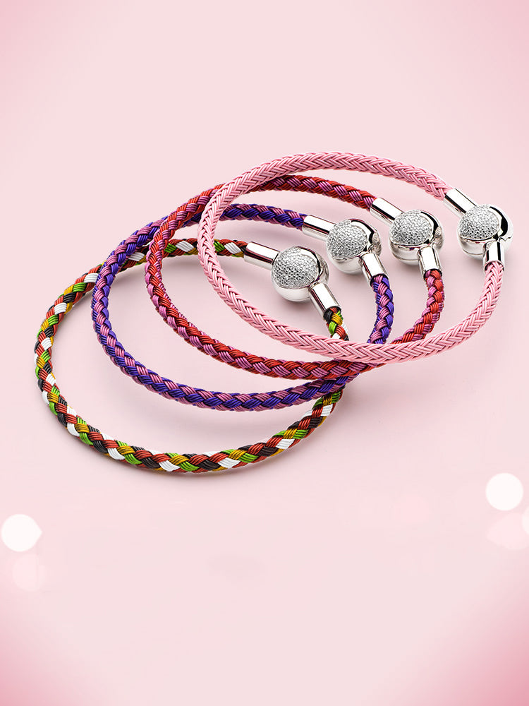 Red and purple braided charm bracelet worn on wrist with sterling silver heart clasp