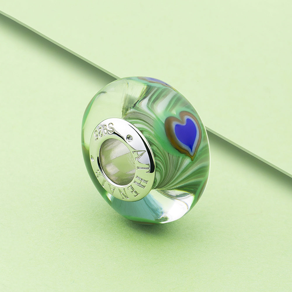 Royal Feather Murano glass charm bead displayed in decorative scene.