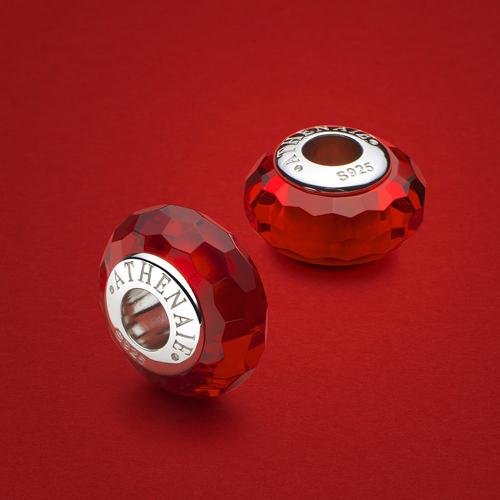 Ruby Gleam faceted Murano glass charm bead in a decorative jewelry scene, handcrafted ruby red glass charm