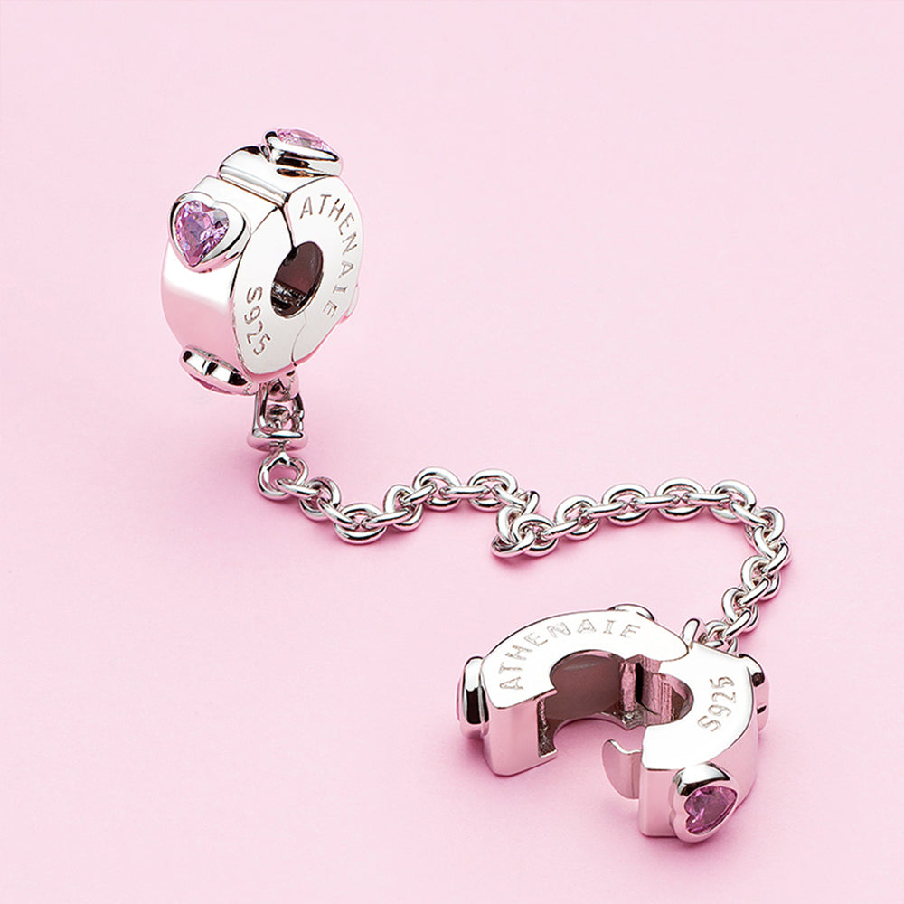 Pink heart safety chain close-up scene with dangling charms
