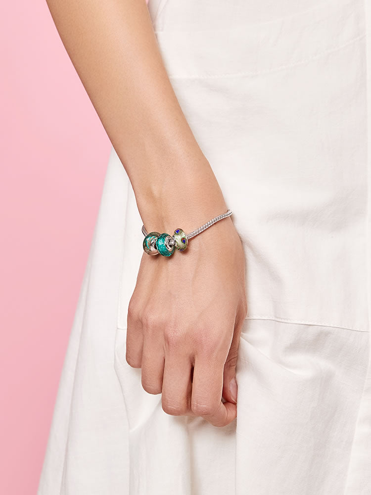 Sterling silver wheat chain charm bracelet worn on wrist