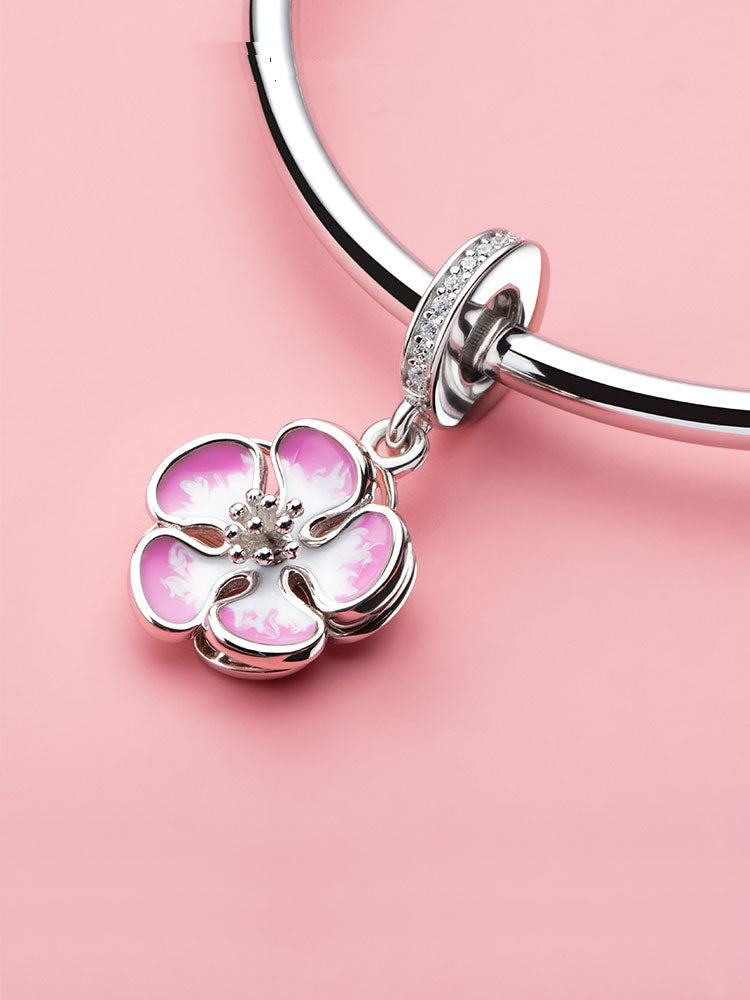 Spring blossom enamel dangle charm styled on bracelet