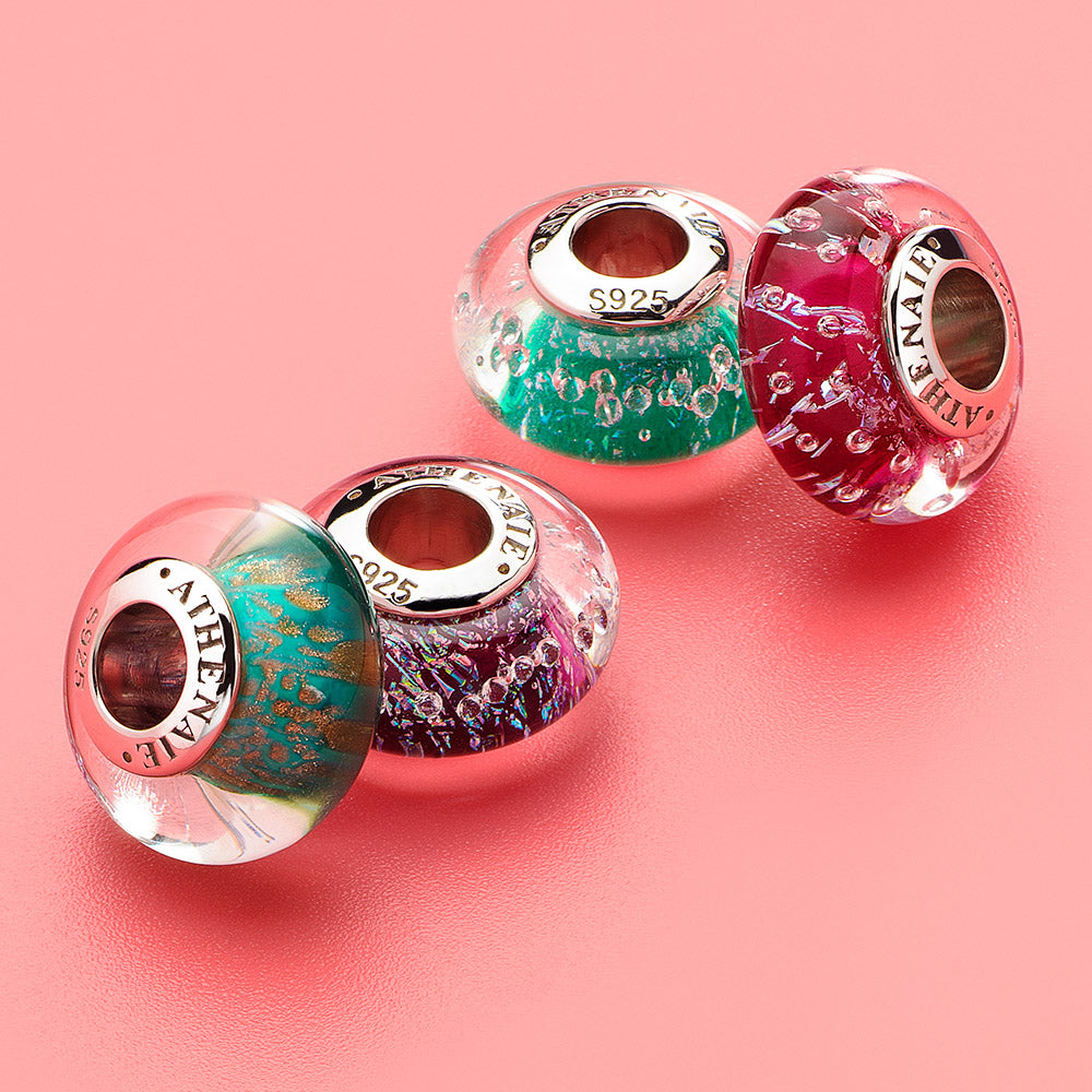 Lifestyle view of Stardust Whisper Murano glass charm in deep purple tones with cosmic shimmer and silver detailing