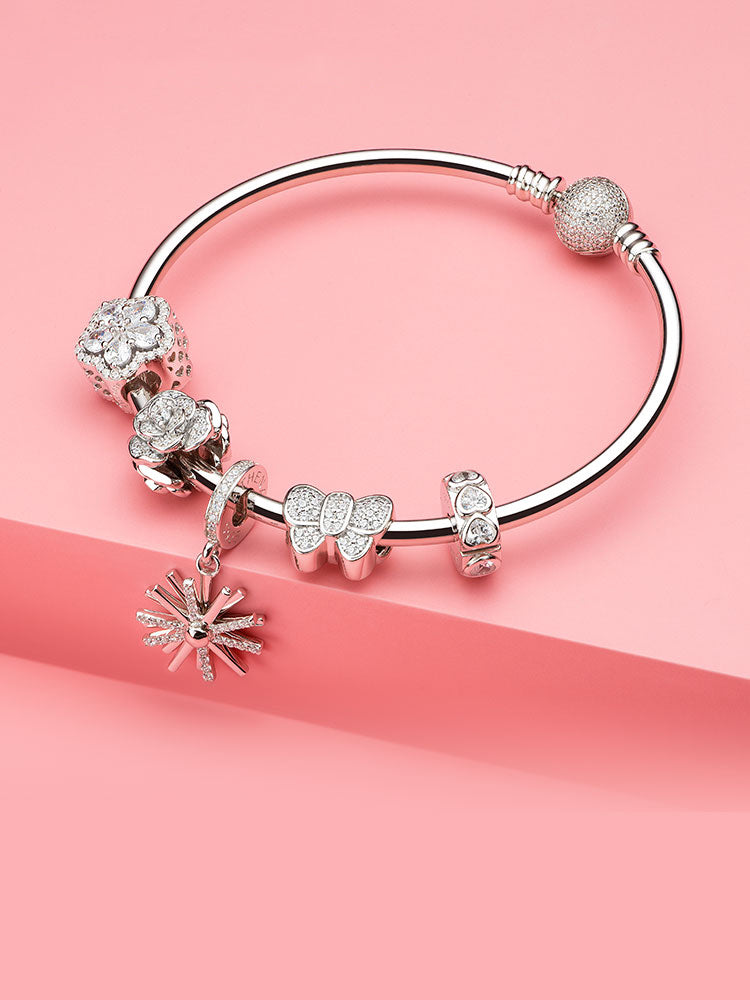 Sterling silver starburst charm styled on bracelet