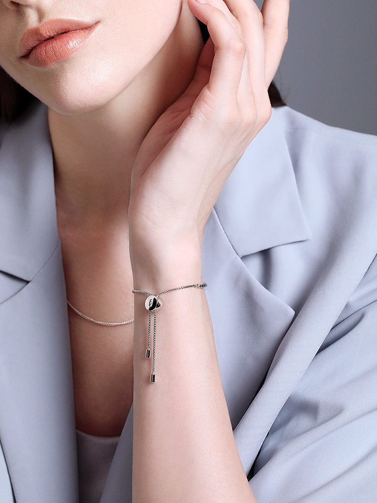 Sterling silver adjustable charm bracelet with white CZ worn on wrist